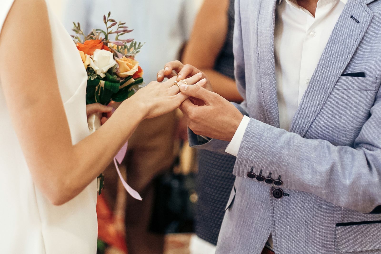 bride with bouquet and groom exchanging wedding ri btlel8j