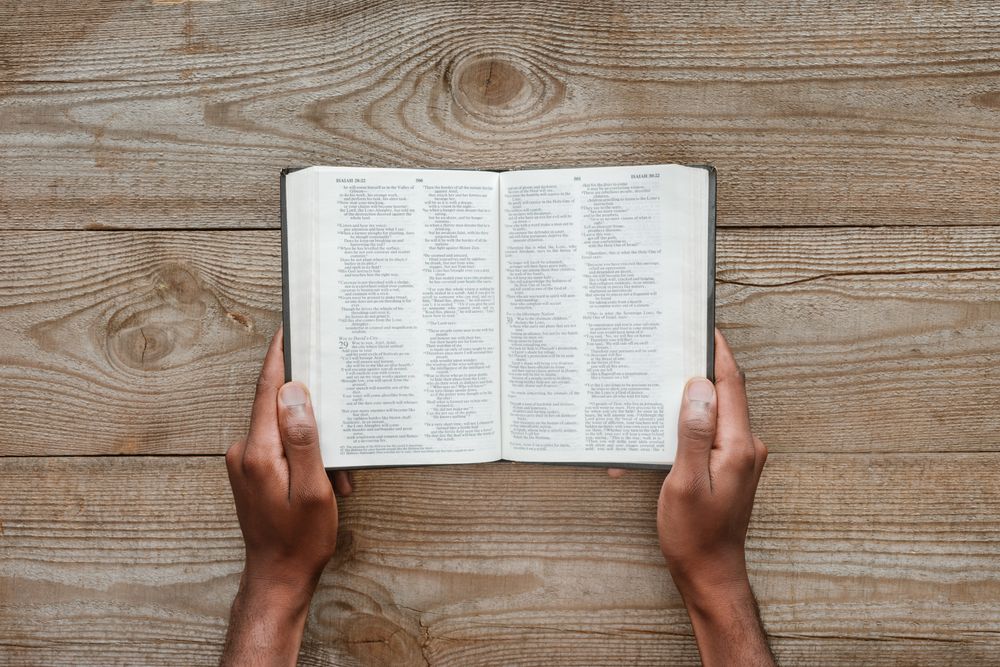 cropped shot of man holding holy bible over wooden zgqt3qn